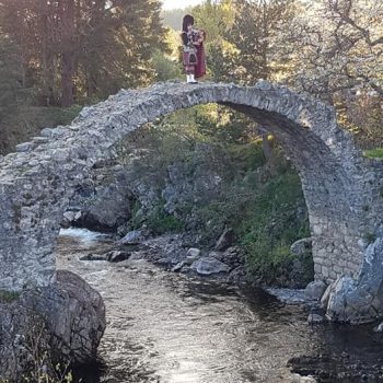 Een Schot die op de doedelzak speelt op een van de oudste bruggetjes van Schotland