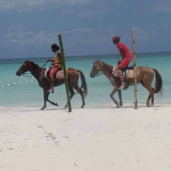 Gekleurd geklede Jamaicanen op  prachtige witte Negril strand.