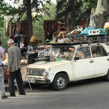 Een vlooienmarkt met een vol gezette auto